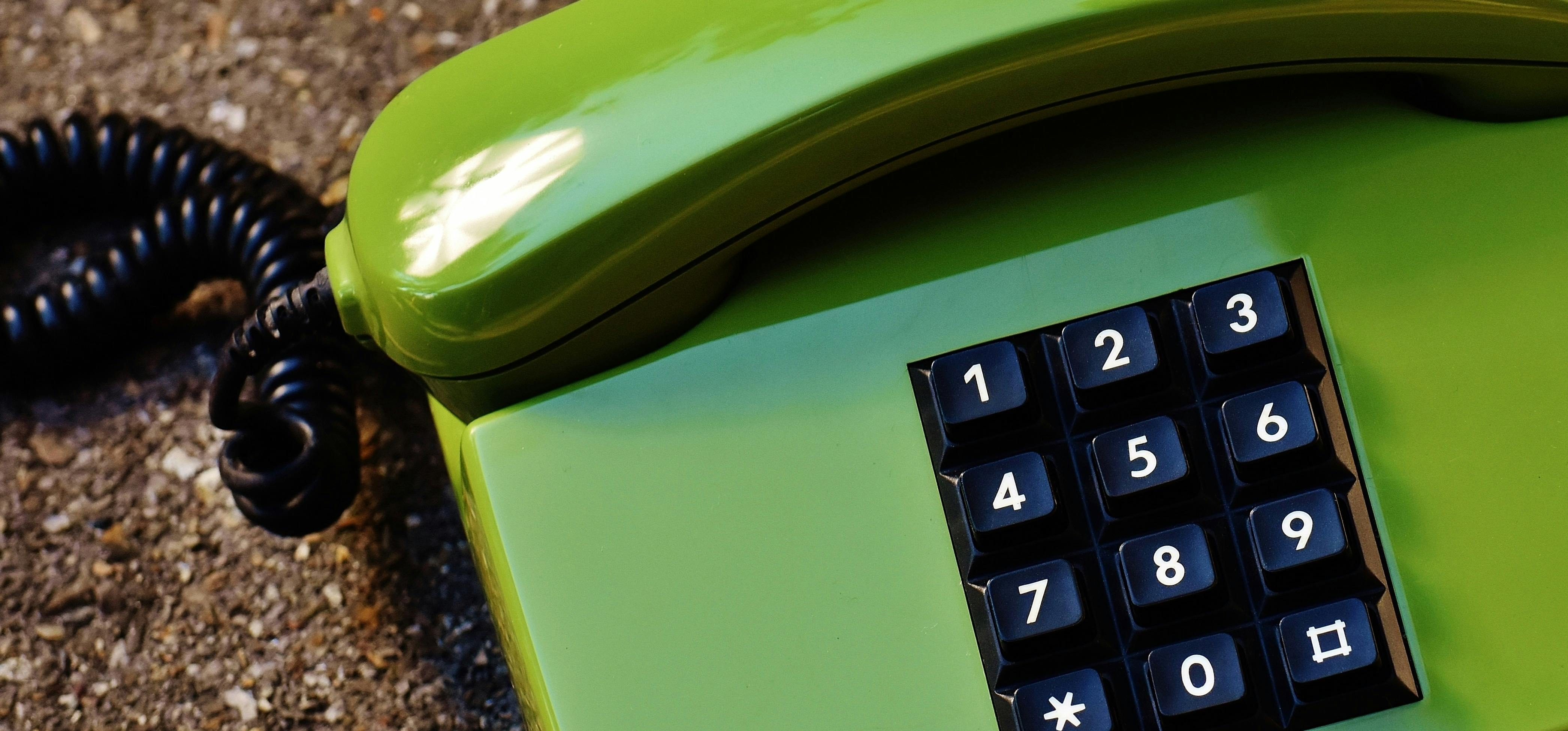 banner image, pistachio green telephone with black buttons and cord